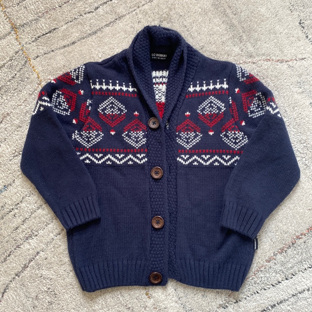 Navy cardigan sweater with shawl collar and red and white intarsia design